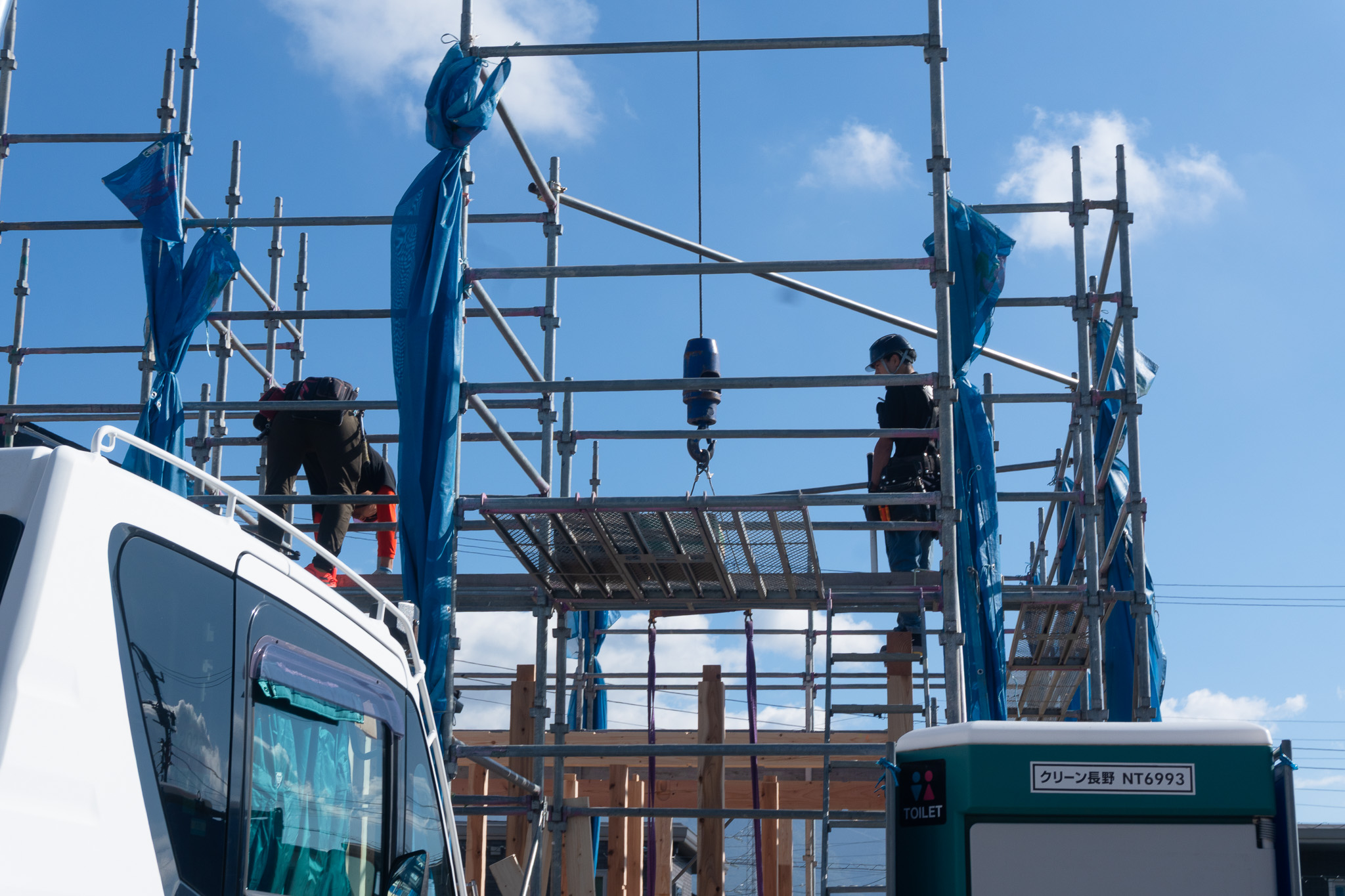 クレーンを使い家の骨格を組み立てる上棟作業